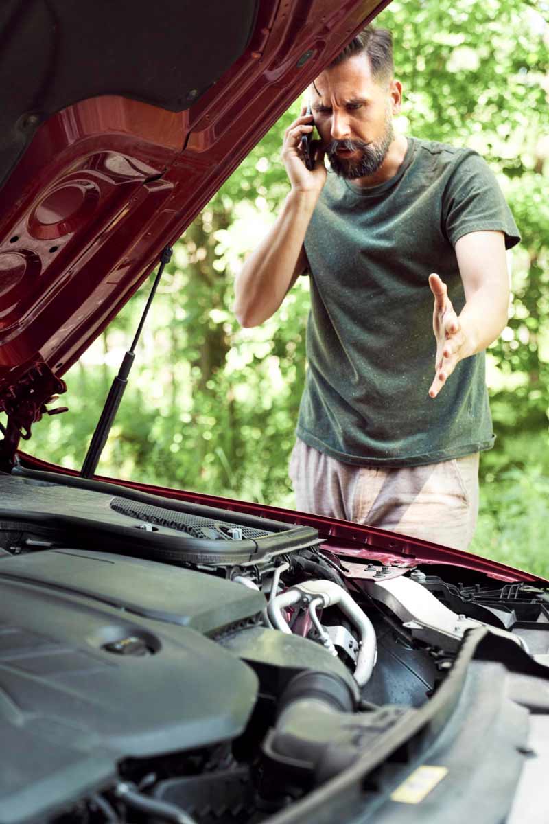 Junger Mann prüft Getriebeschaden bei Schrottauto Ankauf Hofgeismar